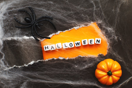 curl of torn black paper on orange background. halloween sale concept.の写真素材