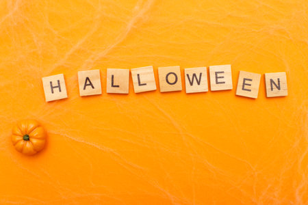the inscription halloween sale with little pumpkin on orange background with spider web.の写真素材