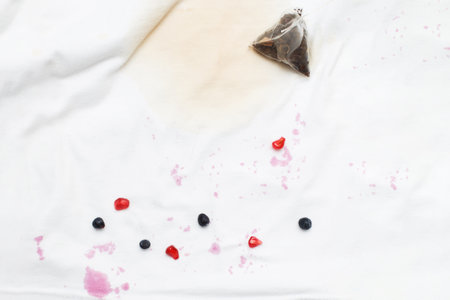 dirty stains on a white T-shirt from berries and drink on brown background.の写真素材
