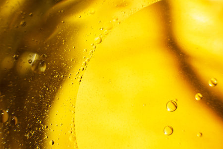 Gold Oil bubbles close up. circles of orange water macro. abstract shiny yellow background.の写真素材