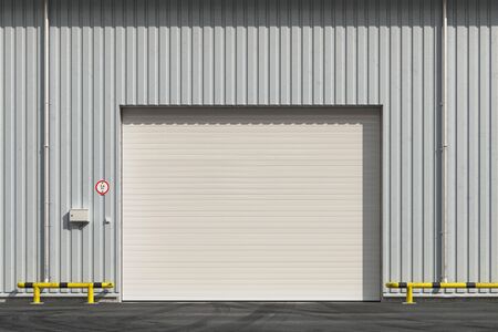 Closed garage with roller shutter door on a city street in the daytime. 3d renderの写真素材