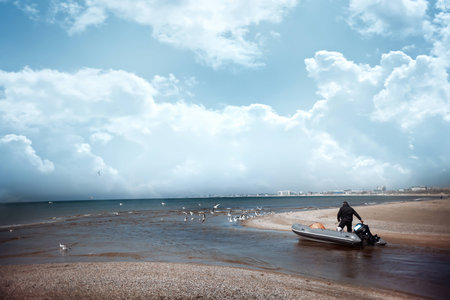 the man goes next to his motor boat and they go to the seaの写真素材
