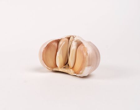 half garlic lies on a white table in the kitchenの写真素材