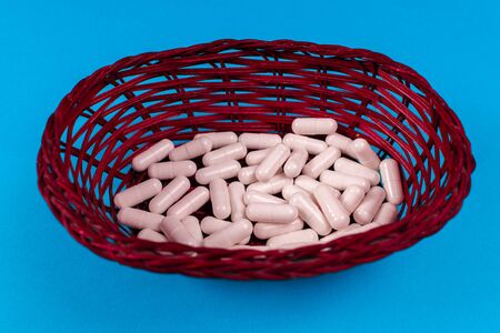 White pills are in the basket. Blue background