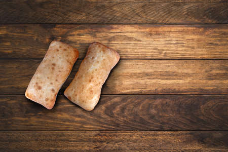 Warm pastries are placed on a wooden table. space for textの写真素材