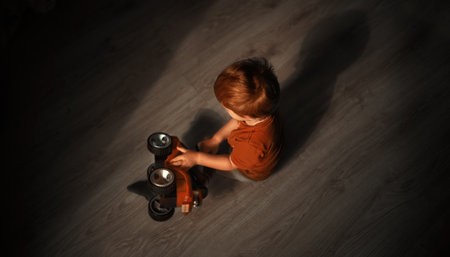 A boy with red hair plays on the floorの写真素材