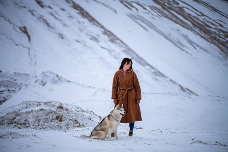 Girl with dog breed husky stands in winter park