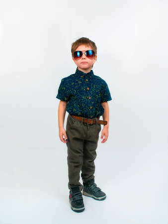 A little boy in trousers and a shirt. Photo in the studio on a white backgroundの写真素材