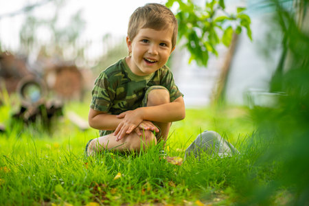 a boy in a green T-shirt sitting on the grassの写真素材