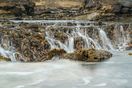 seascape is very beautiful with coral rocks and sea water that looks very soft like cotton at Sawarna Beach, Indonesia. slow shutter speed effectの写真素材