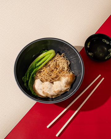 Vermicelli soup served with vegetables and pieces of chicken