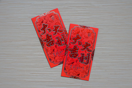 A traditional red angpao used for gifting money during Chinese New Year, isolated on a wood table...