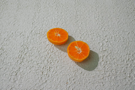 A sliced orange showcasing its juicy interior, isolated on a white background, symbolizing...