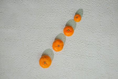 Fresh orange tangerine with green leaves, isolated on a white background. This vibrant citrus fruit...