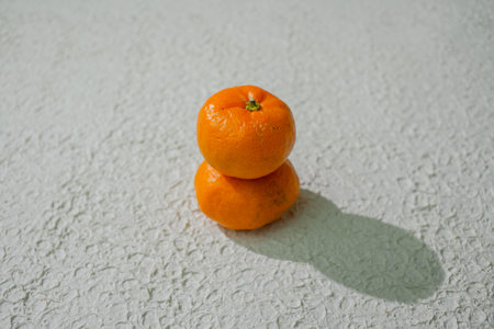 Fresh orange tangerine with green leaves, isolated on a white background. This vibrant citrus fruit symbolizes health, freshness, and tropical flavorの写真素材
