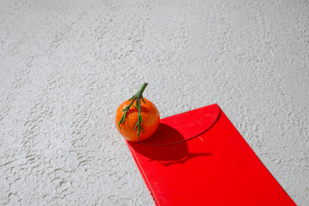 Red angpao and tangerine or mandarin oranges isolated on a white background, symbolizing prosperity, good fortune, and happiness in Chinese celebrationsの写真素材