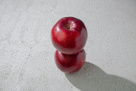 Two deep red apples isolated on a clean white background, symbolizing health, freshness, and natural goodness, perfect for food related visualsの写真素材