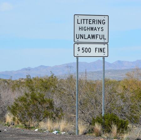 Littering Highways Unlawful Sign with litter on the ground below. Mohave County, Sonoran Desert,...