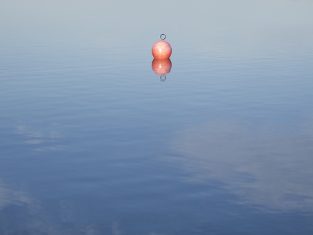 A red buoy in a blue lakeの写真素材