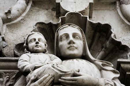 An old statue of a woman holding a child (Mary and Jesus).の写真素材