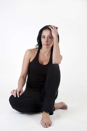 Woman in exercise clothes, sitting on the floor