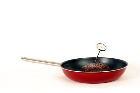 cooking hamburger in a frying pan with a thermometerの写真素材