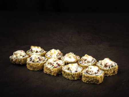 Portion of hot rolls with cheese in Japanese style, side view, against a dark background.の写真素材