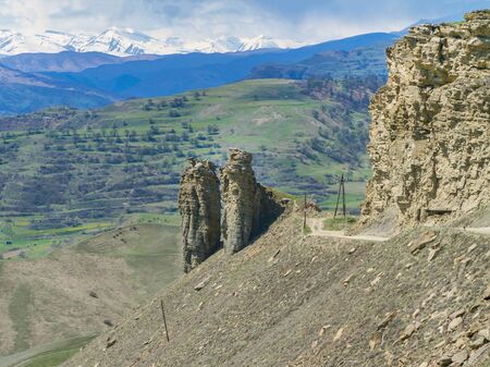 Stone pillars of natural origin on a mountain road in Dagestan on a sunny summer dayの写真素材
