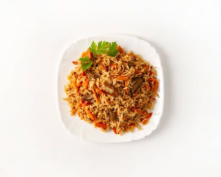 Plate of pilaf with beef on a white background, top view. Traditional cuisine of Central Asia. Dinner at home. Close-upの写真素材