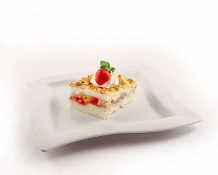 A serving of tender berry dessert sprinkled with grated walnuts on a plate, closeupの写真素材