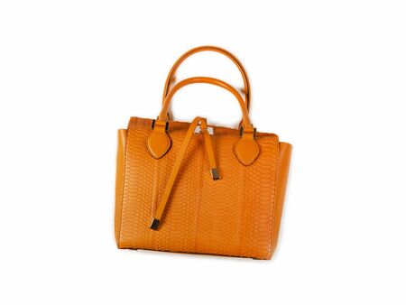 Yellow women bag made of python skin, lying on its side. Bag handles and leather straps are clearly visible. Isolateの写真素材