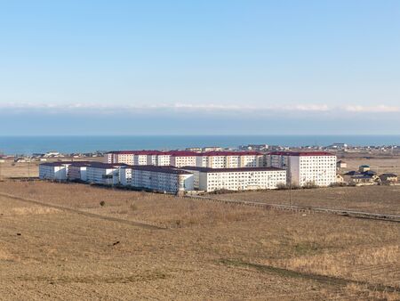 The residential neighborhood is surrounded by harvested vineyards, near the sea. Sunny autumn day, light cloudsの写真素材