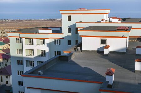 A fragment of the roof of a modern high-rise building with technical rooms and fresh air ventilation shaftsの写真素材