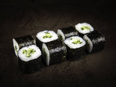 A portion of Japanese rolls, rice with avocado slices wrapped in nori seaweed, close-up. Selective focusの写真素材