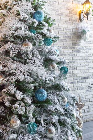 The Christmas tree is decorated with artificial snow and balls. Vertical layout, selective focusの写真素材