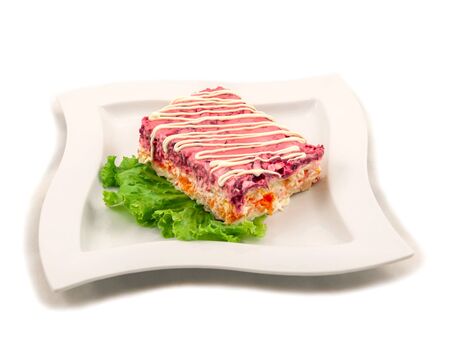 A portion of boiled vegetable salad decorated with mayonnaise and served on a lettuce leaf. Russian kitchen. Side view, selective focus. Isolated on white backgroundの写真素材