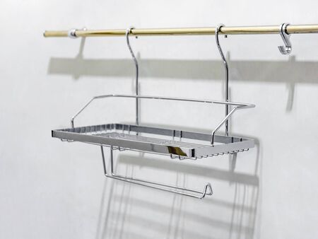A shelf of chromed rods is fixed to the bar for clothes. Close-up. Soft focusの写真素材