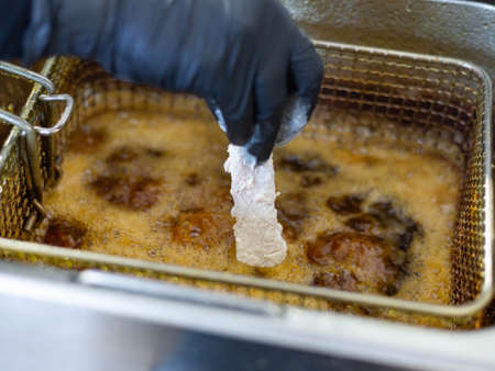 The process of preparing a dish from deep-fried chicken. Danger in the kitchen. Carcinogens in foodの写真素材