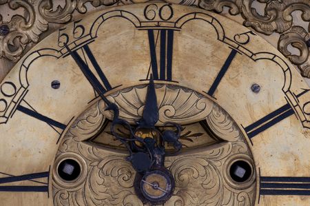 Old clock showing five to twelve on the dial