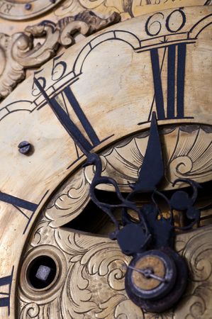 Old clock showing five to twelve on the dialの写真素材