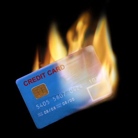 Bank credit card in flames on black backgroundの写真素材