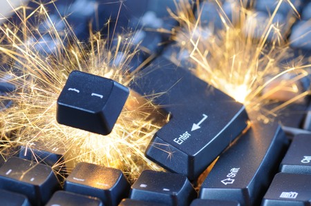 Black exploding computer keyboard with electric sparks.の写真素材