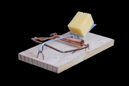 Mousetrap with a piece of cheese on black background.の写真素材
