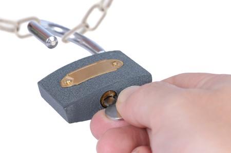 Hand opening metal padlock isolated on whiteの写真素材