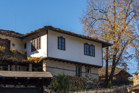 Panorama with autumn tree and old house in village of Bozhentsi, Gabrovo region, Bulgariaのeditorial素材