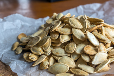 Grilled Pumpkin seeds with sea salt and spices on the wooden backgroundの写真素材