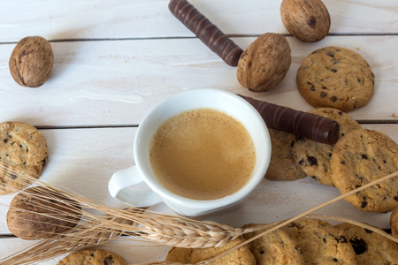 Cup of coffee, cookies, walnut and chocolate on the white wooden backgroundの写真素材