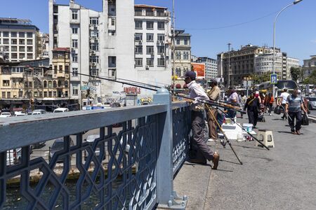 ISTANBUL, TURKEY - JULY 27, 2019: Fishermen on Galata bridge and Golden Horn in city of Istanbul, Turkeyのeditorial素材