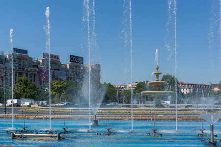 BUCHAREST, ROMANIA - AUGUST 17, 2021: Fountain at Unirii Square at the center of city of Bucharest,...