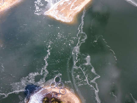 Aerial winter view of Dospat Reservoir covered with ice, Smolyan Region, Bulgaria